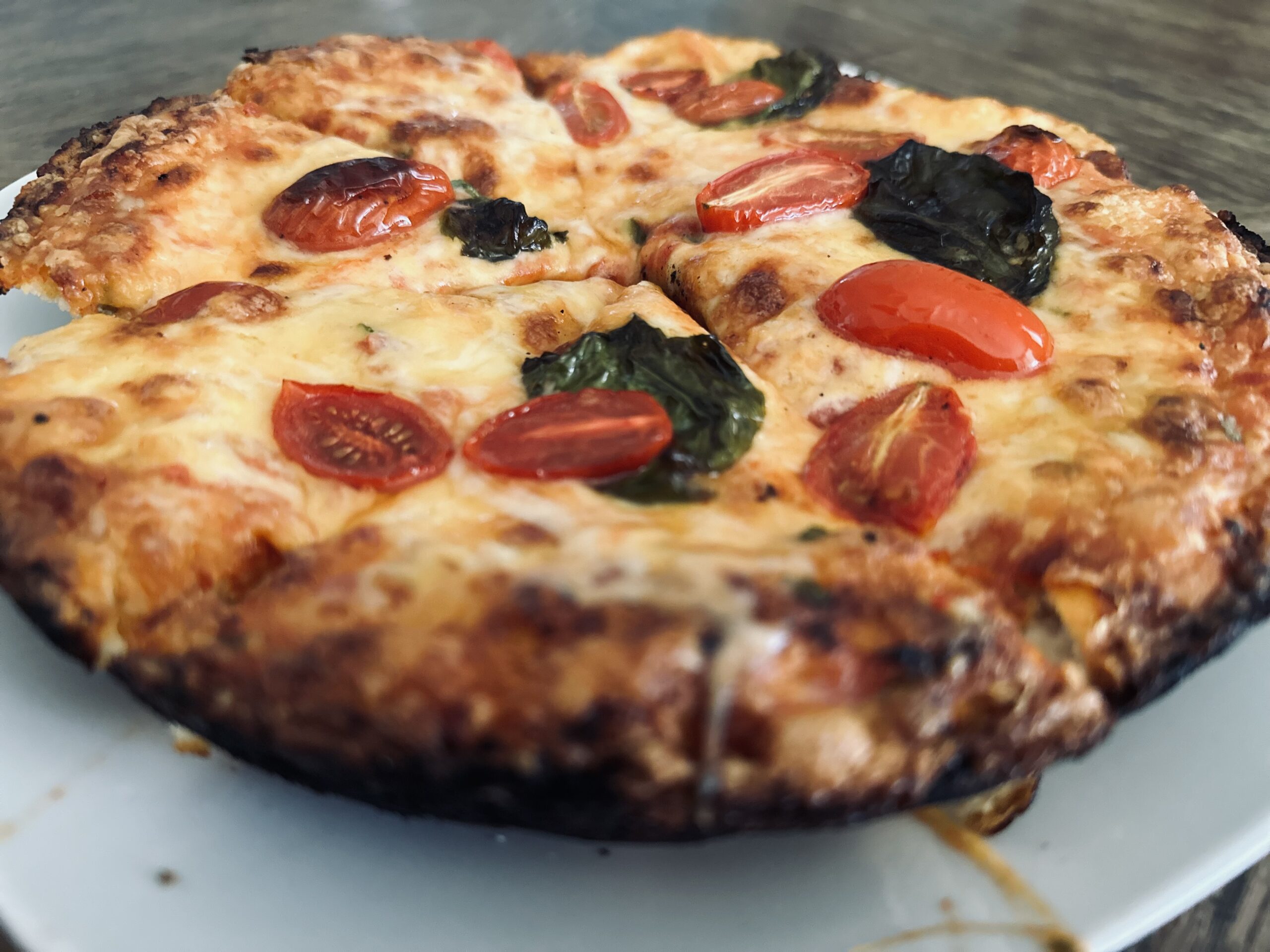 homemade pizza with cheese, tomatoes, and basil